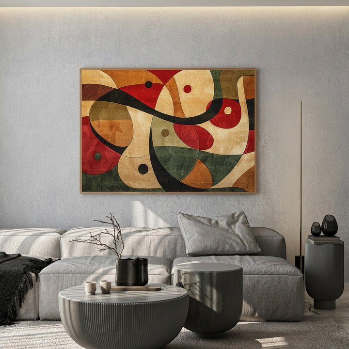 Wadi Home abstract geometric canvas print with red, green, and ochre tones displayed above a modern grey sofa.