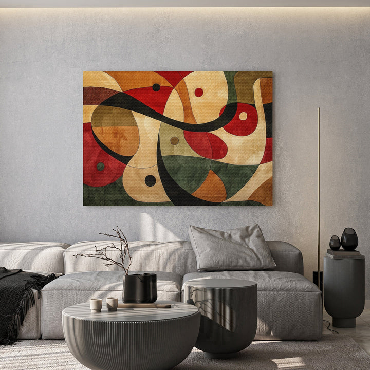 Wadi Home abstract geometric canvas print with red, green, and ochre shapes hanging above a modern grey sofa.