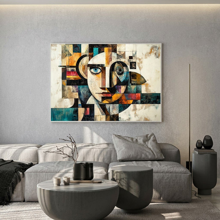 Wadi Home abstract geometric face canvas print with teal and ochre tones hanging above a modern grey sofa.