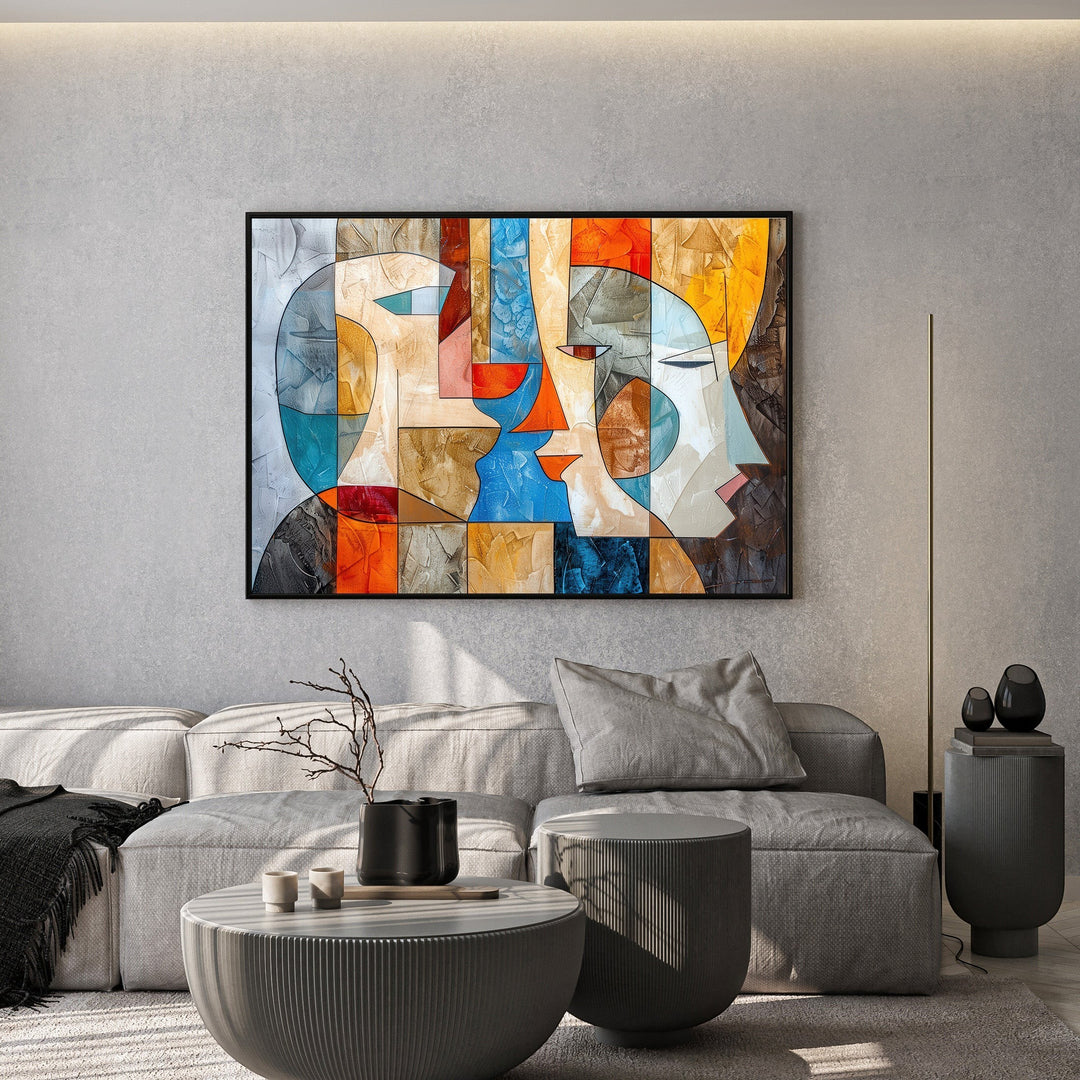 Wadi Home abstract geometric faces canvas art with vibrant orange and blue tones hanging above a modern grey sofa.
