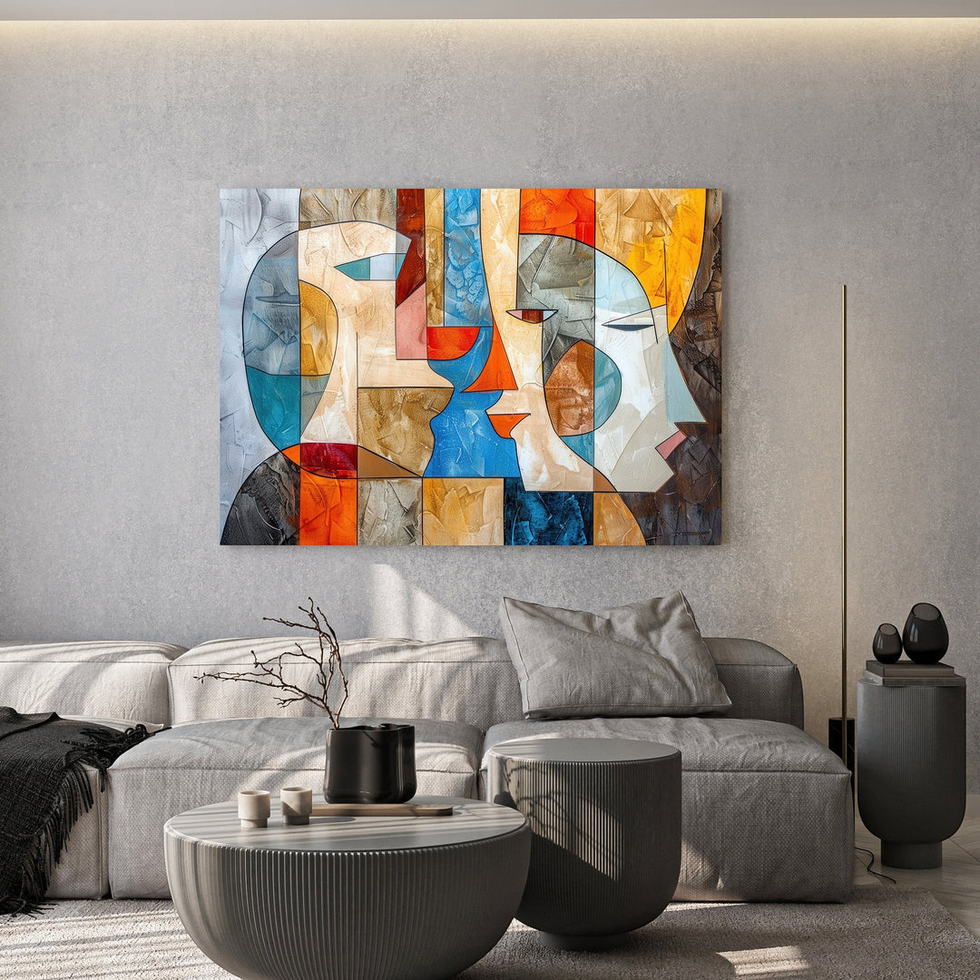 Wadi Home abstract geometric faces canvas art with vibrant orange and blue tones hanging above a modern grey sofa.