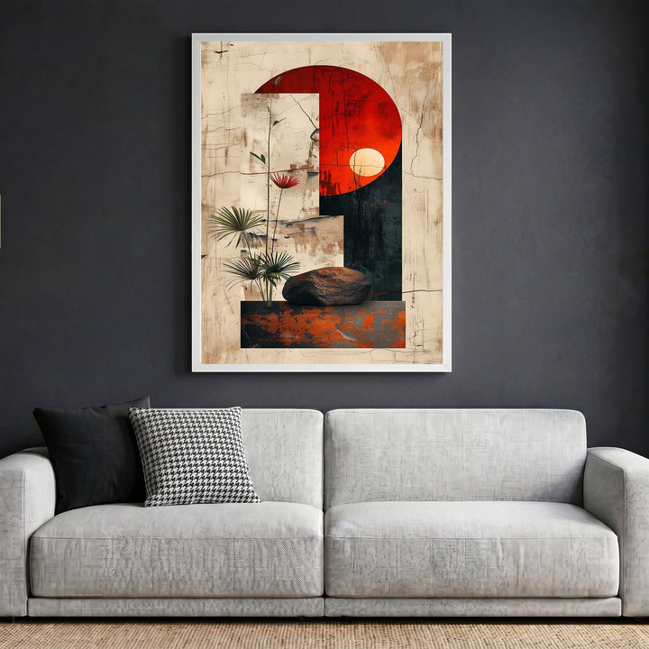 Wadi Home abstract geometric wall art with a red sun motif and botanical accents in a white frame above a grey sofa.