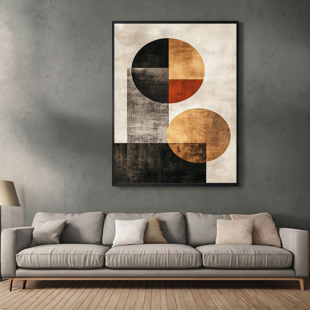 Wadi Home abstract geometric wall art print with black, ochre, and orange circles hanging above a modern grey sofa.