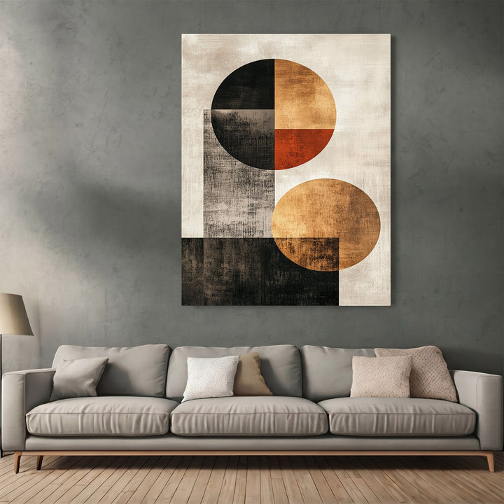 Wadi Home abstract geometric wall art print with black, ochre, and orange circles hanging above a grey sofa.