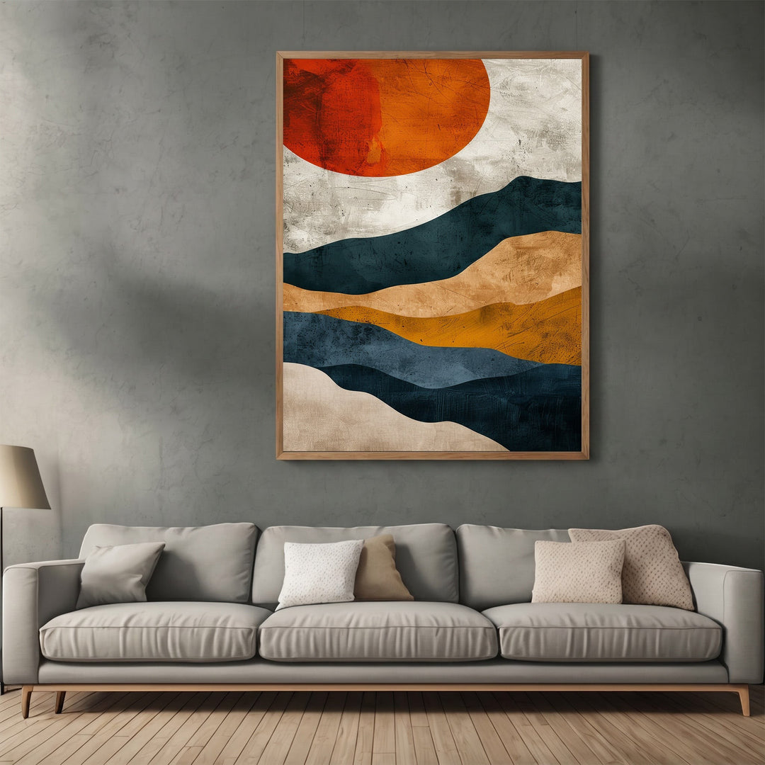 Wadi Home abstract landscape wall art print featuring navy, ochre, and burnt orange sun above a grey sofa.
