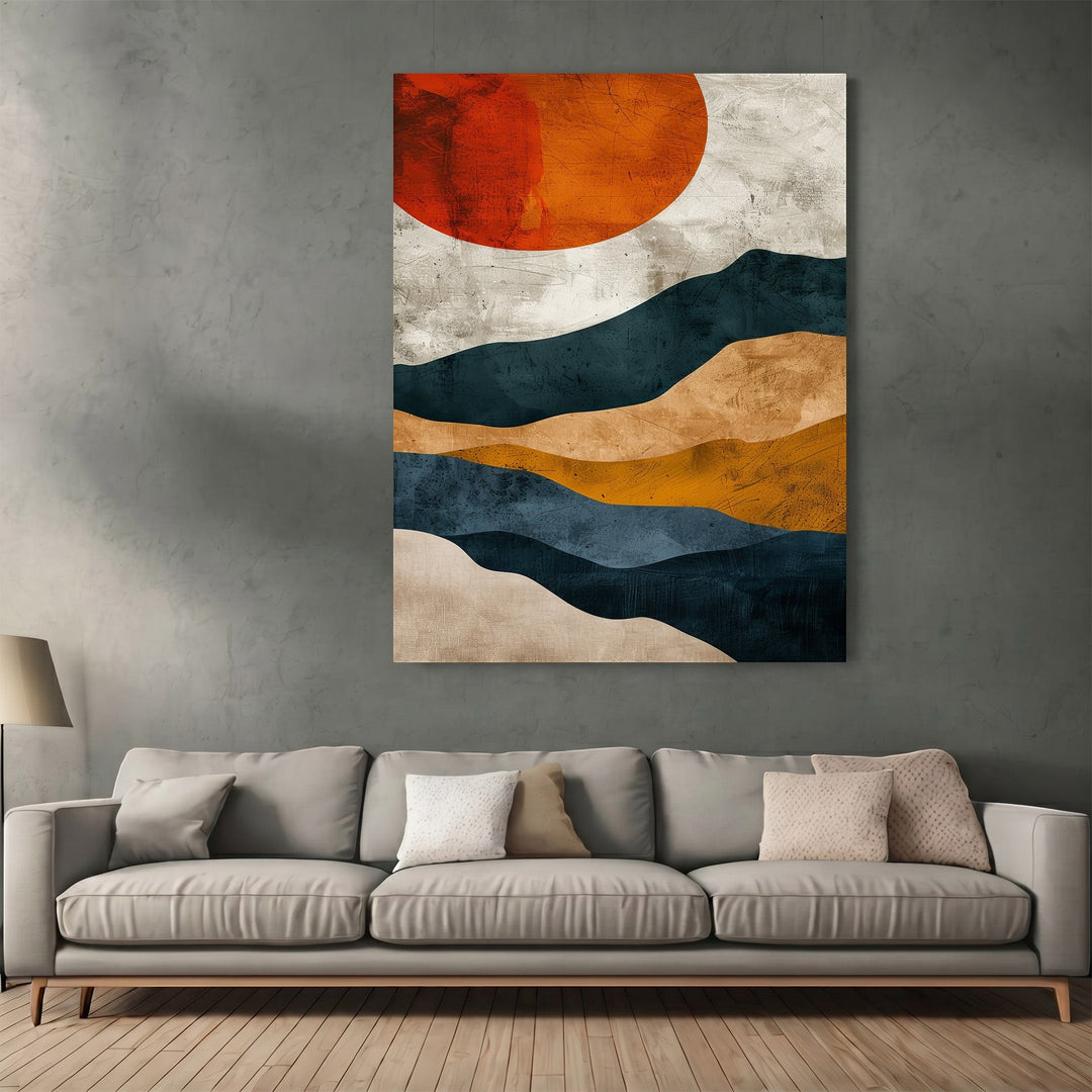 Wadi Home abstract landscape wall art print featuring navy, ochre, and burnt orange sun above a modern grey sofa.
