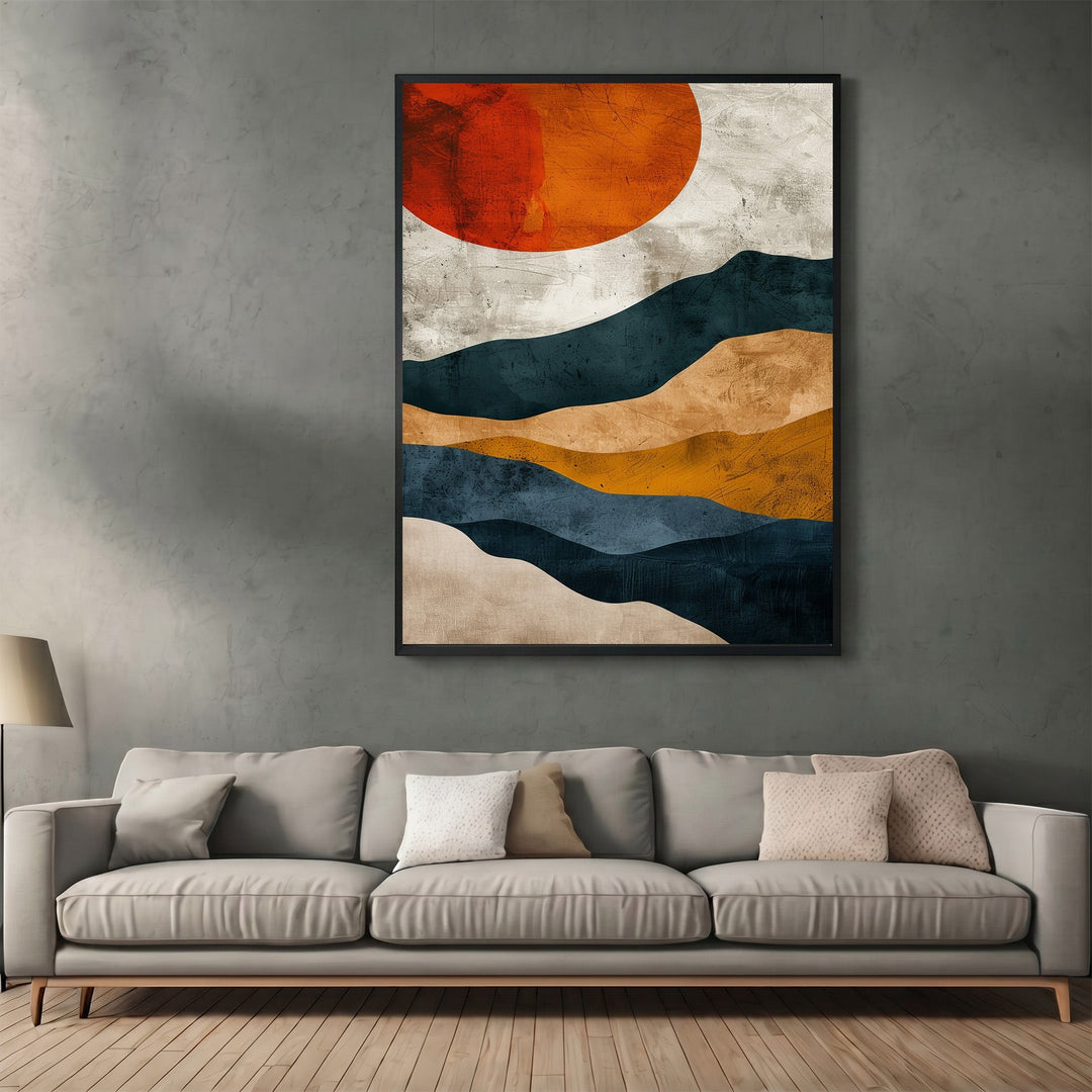 Wadi Home abstract landscape wall art print featuring navy, ochre, and burnt orange sun above a modern grey sofa.