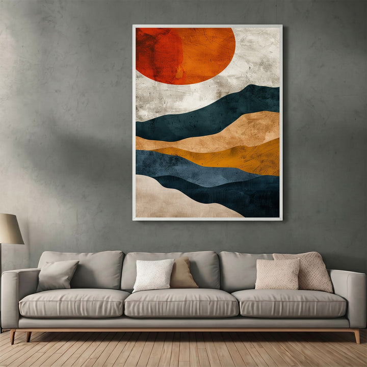Wadi Home abstract landscape wall art print featuring navy, ochre, and burnt orange sun above a grey sofa.