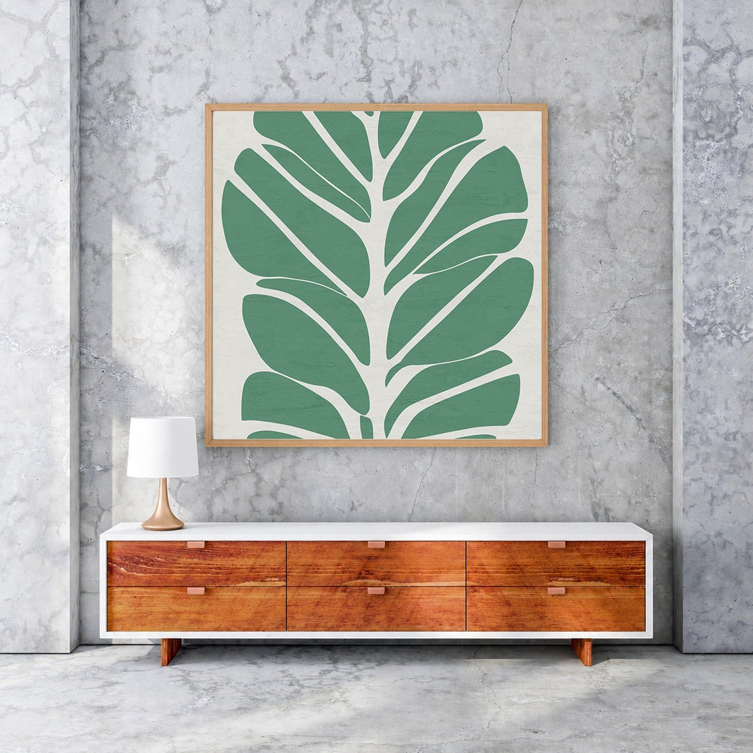 Wadi Home abstract green leaf wall art with a minimalist design on a neutral background, framed in light wood.
