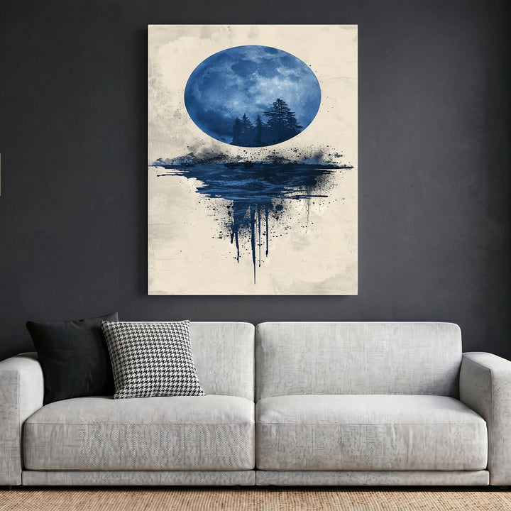 Wadi Home abstract moon landscape wall art with blue watercolor forest silhouette hanging above a modern grey sofa.