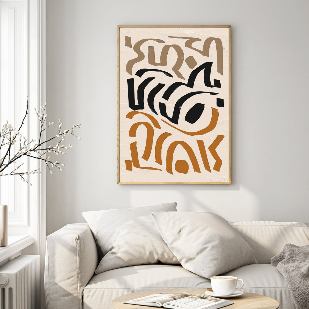 Wadi Home abstract organic shapes wall art in black, tan, and ochre, framed in light wood, displayed above a sofa.