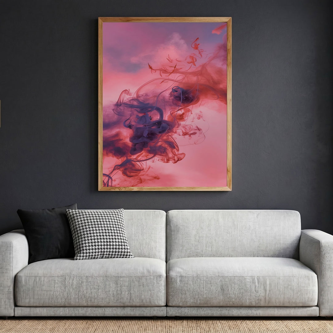Wadi Home abstract smoke wall art print with violet and crimson swirls in a light wood frame above a grey sofa.