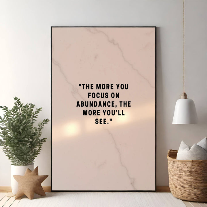 Wadi Home inspirational wall art with black text on a soft pink marble background: "The more you focus on abundance, the more you'll see."