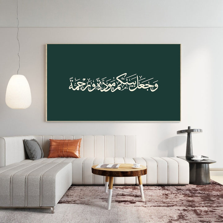Wadi Home Arabic calligraphy wall art with white script on forest green background above a modern beige sofa.