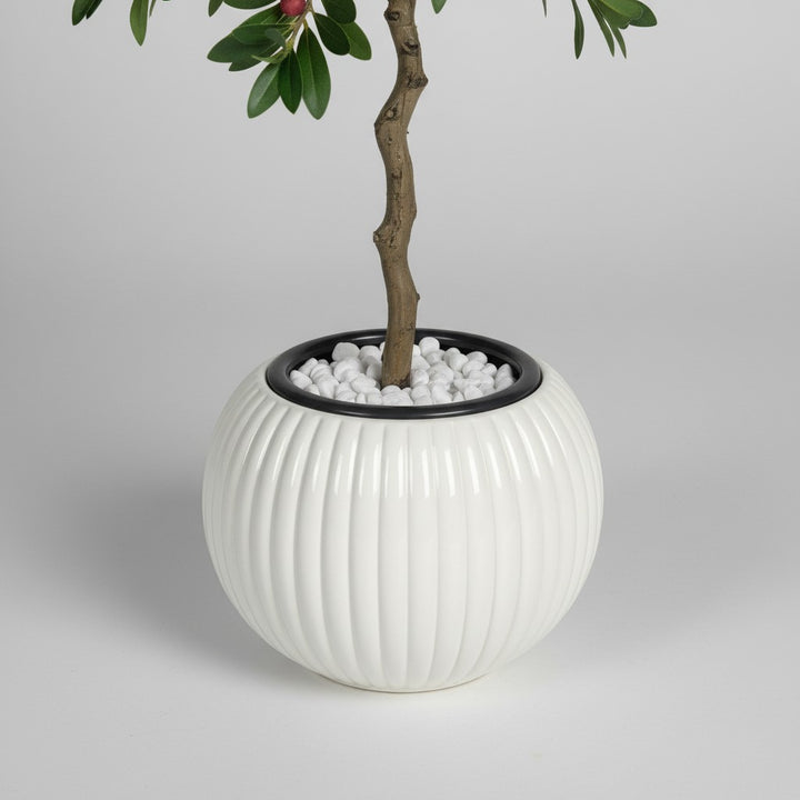 Wadi Home artificial berry tree in a white ribbed ceramic pot with decorative white stones on a neutral background