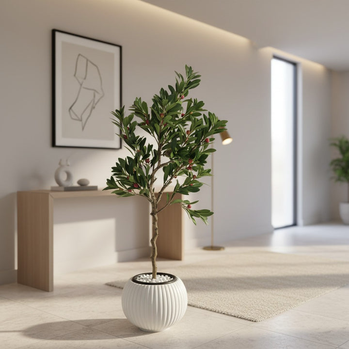 Wadi Home artificial berry tree with green leaves and red berries in a white ribbed pot on a modern living room floor