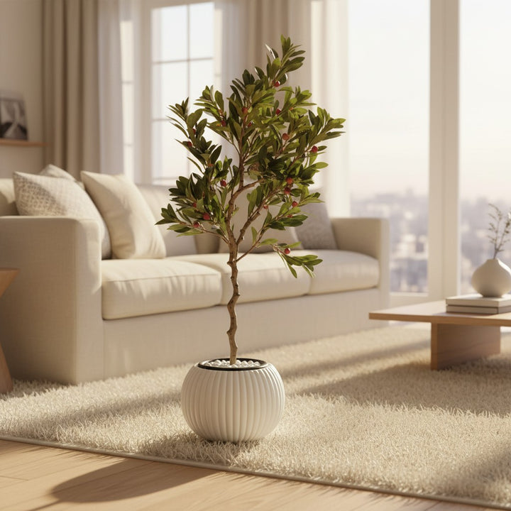 Wadi Home artificial berry tree with green leaves and red berries in a white ribbed pot on a living room rug.