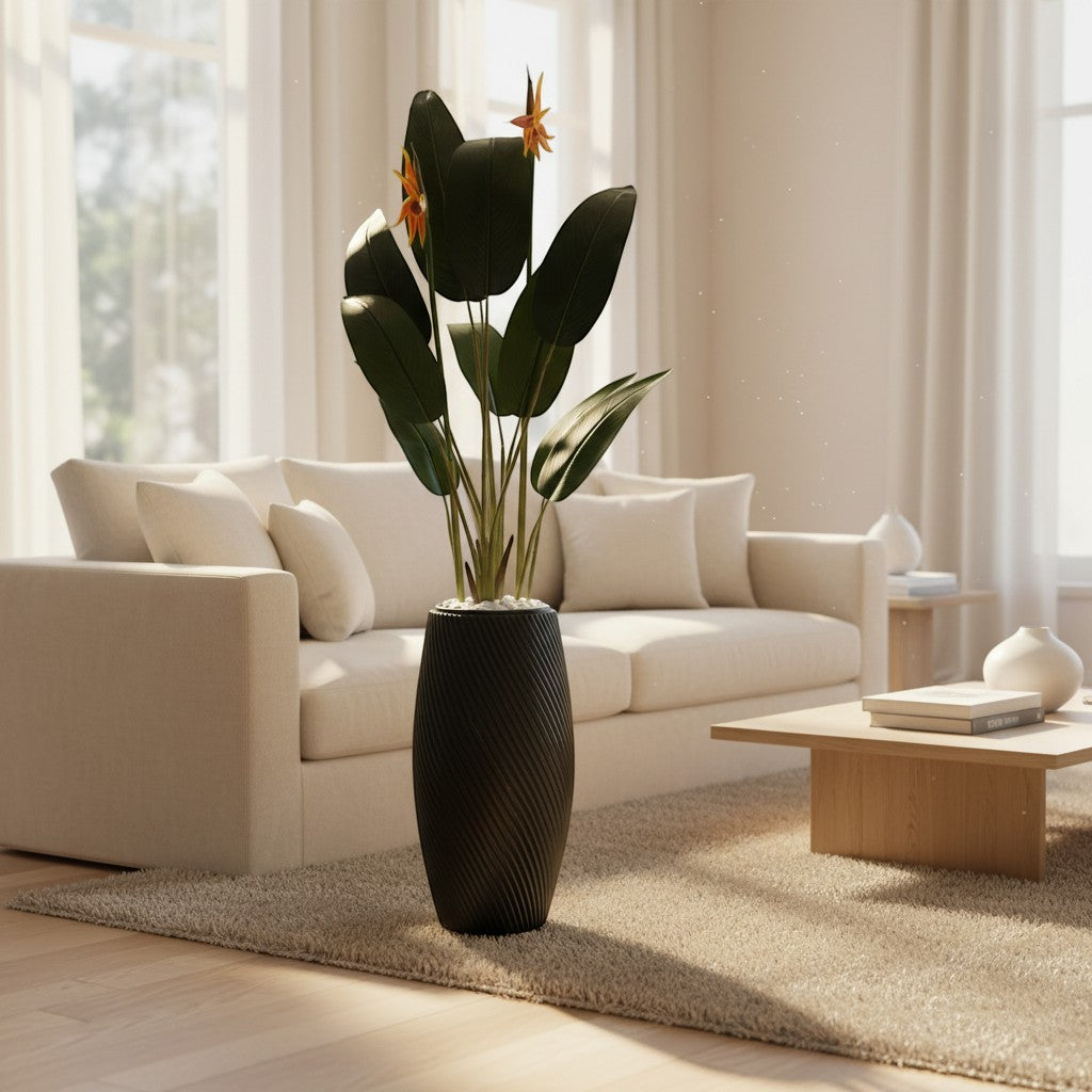 Wadi Home artificial Bird of Paradise plant with orange blooms in a textured black floor planter in a living room.