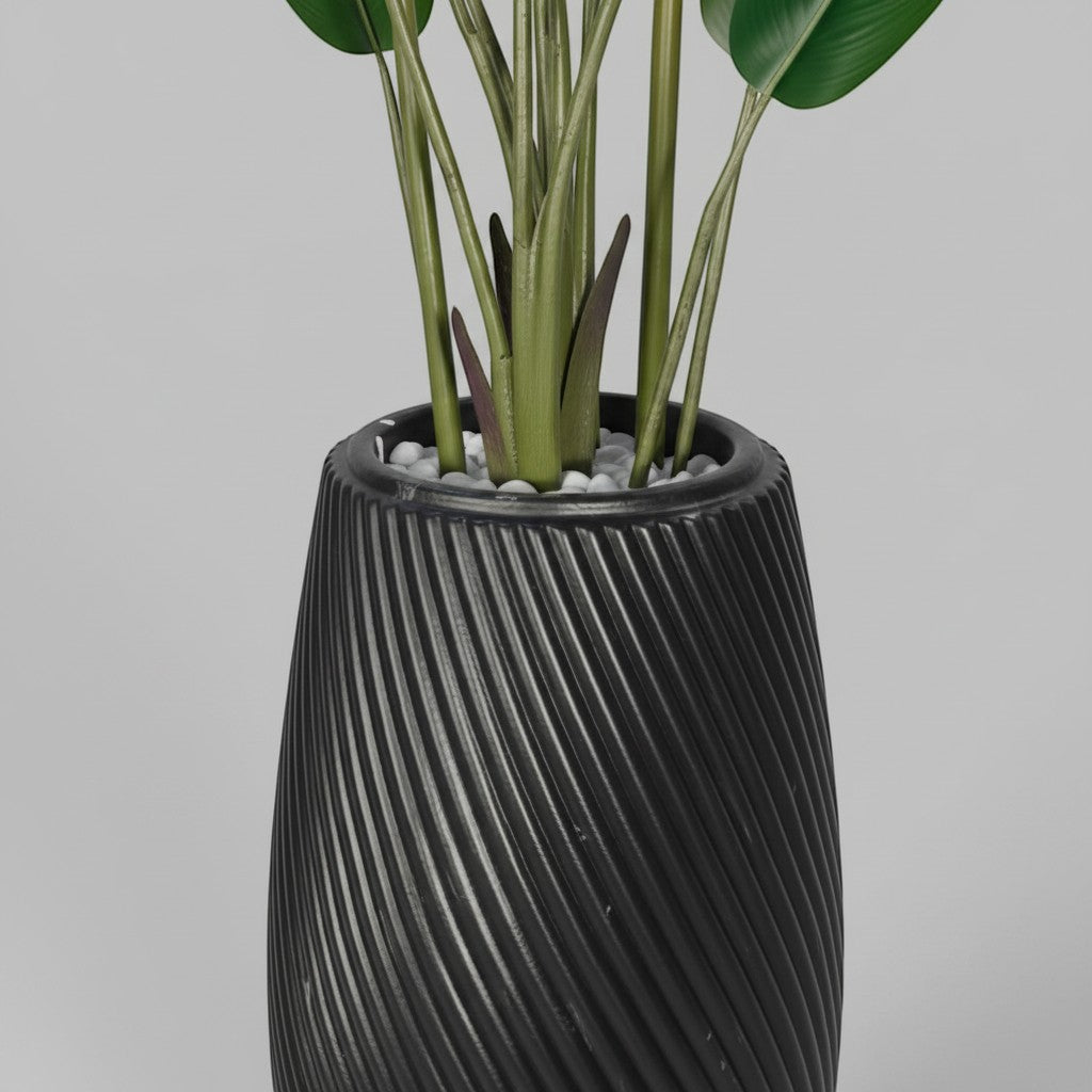 Wadi Home artificial Bird of Paradise plant in a sleek black floor planter with a textured spiral design