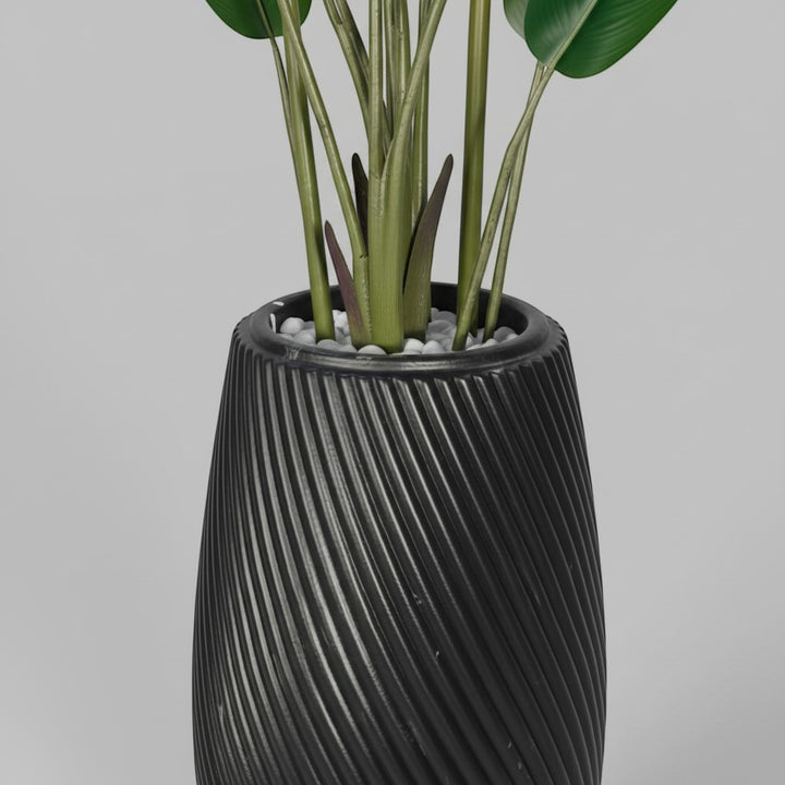 Wadi Home artificial Bird of Paradise plant in a sleek black floor planter with a textured spiral design