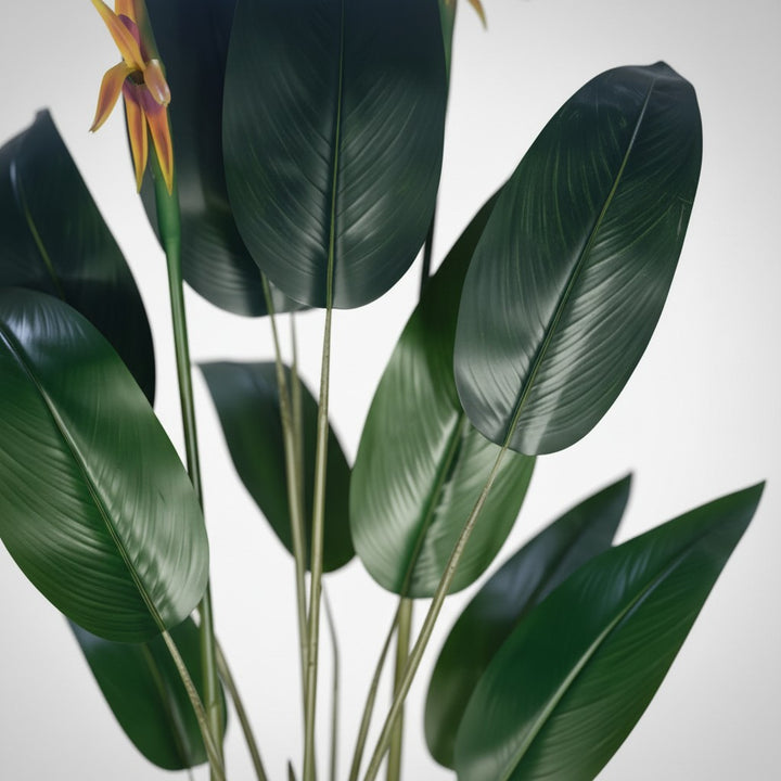 Wadi Home artificial Bird of Paradise plant with deep green leaves and vibrant orange and yellow tropical flowers.