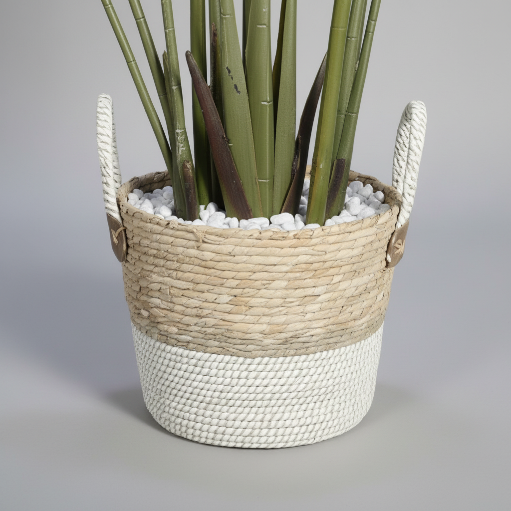 Wadi Home artificial Bird of Paradise plant in a two-tone woven basket with white decorative stones at the base.