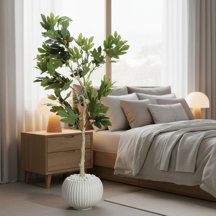 Wadi Home artificial cypress tree with lush green foliage in a ribbed white pot, placed in a modern bedroom.