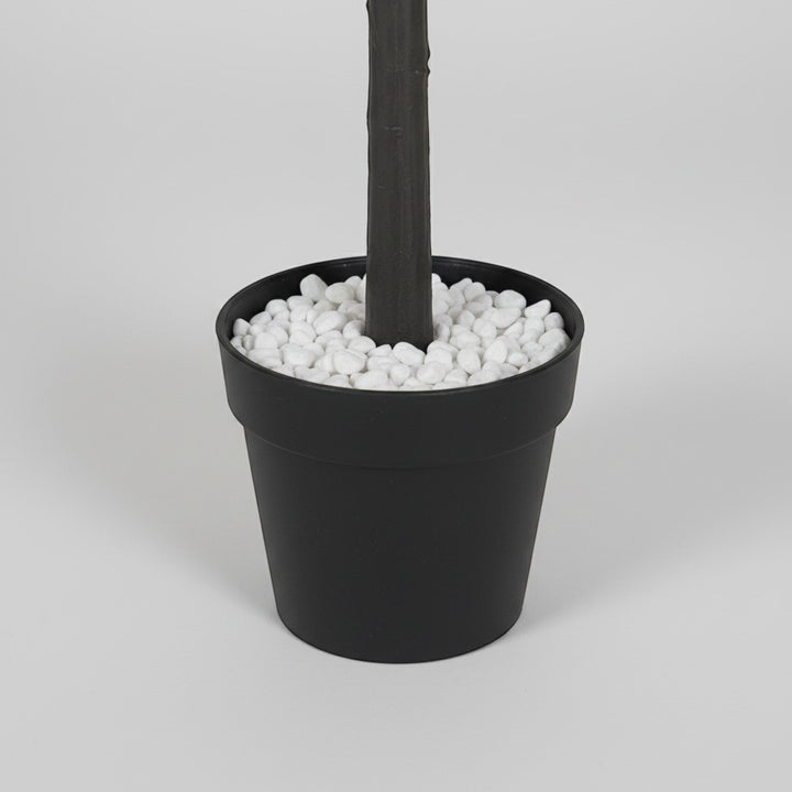 Wadi Home artificial eucalyptus tree in a black pot with decorative white pebbles at the base