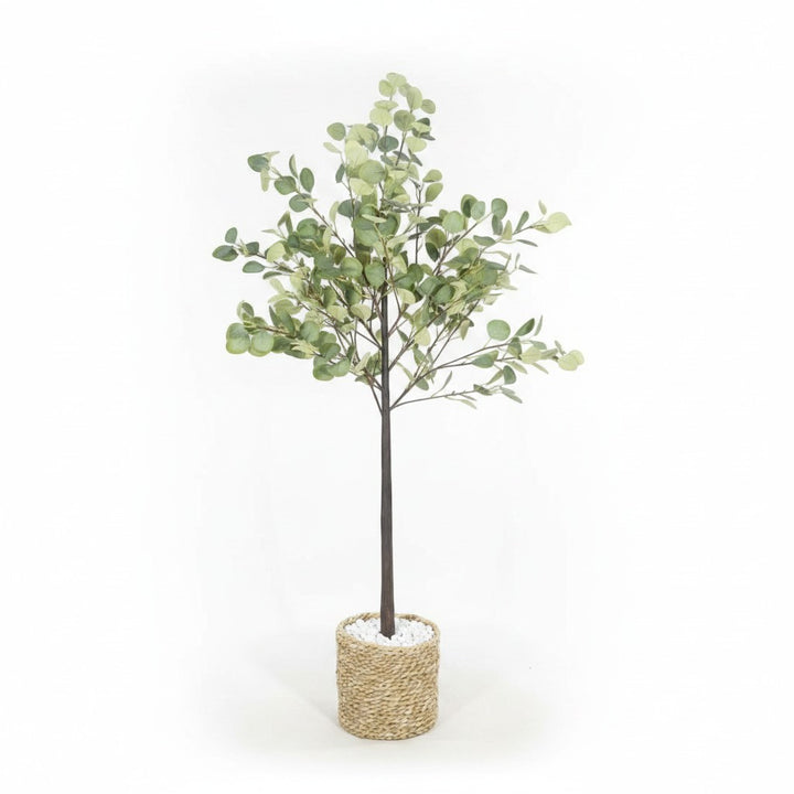 Wadi Home artificial eucalyptus tree with soft-green leaves in a textured woven basket with white decorative stones.