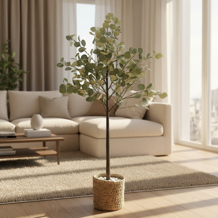 Wadi Home artificial eucalyptus tree with soft-green leaves in a woven basket with white stones in a bright living room