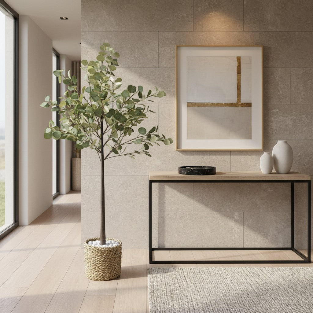 Wadi Home artificial eucalyptus tree with soft-green leaves in a textured woven basket, placed in a modern entryway.