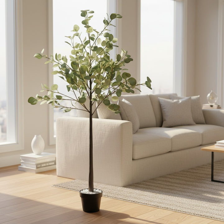 Wadi Home artificial eucalyptus floor plant with lush green leaves in a black pot, styled in a bright living room.