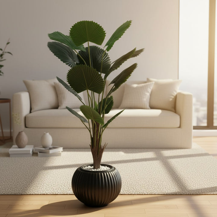 Wadi Home artificial fan palm plant with deep green leaves in a ribbed black ceramic planter on a living room rug.