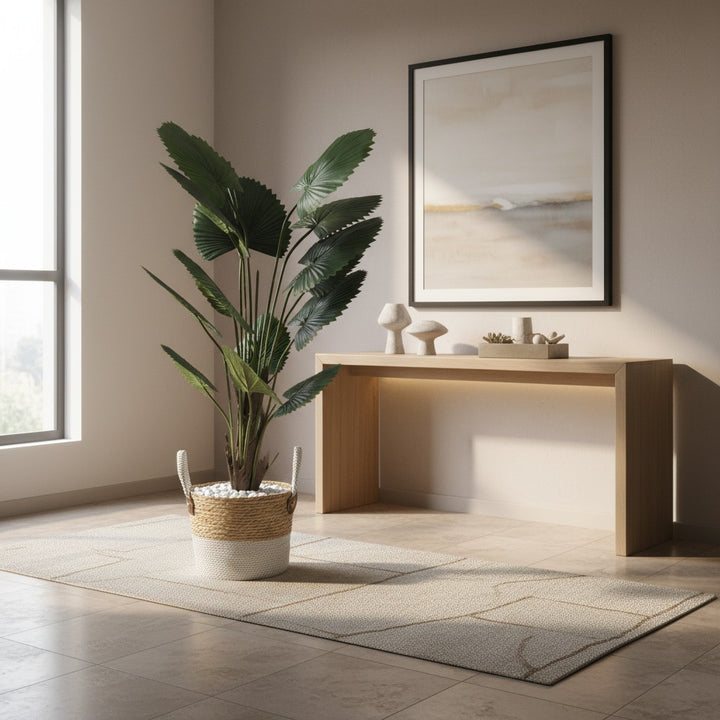 Wadi Home artificial fan palm plant with deep green leaves in a two-toned woven basket with white stones in a room.
