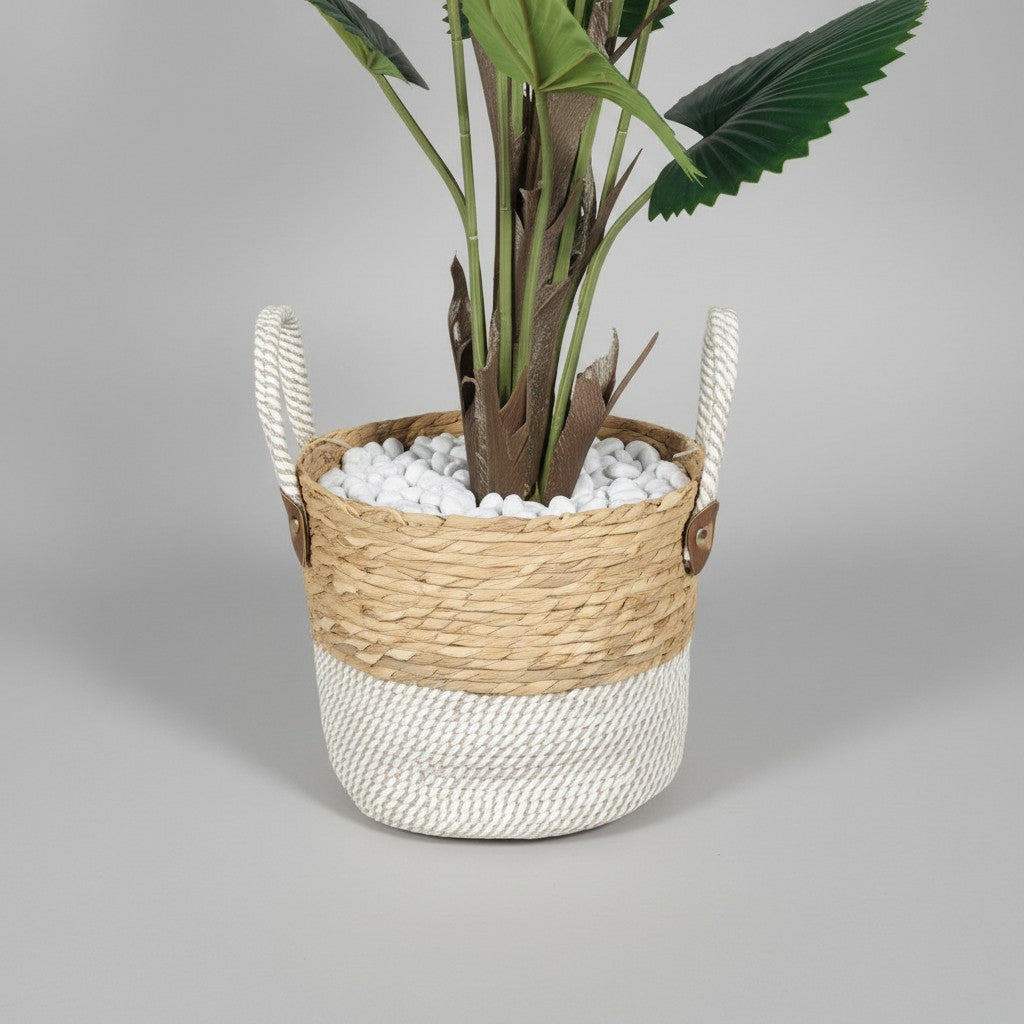 Wadi Home artificial fan palm plant in a two-toned woven basket with white decorative stones and sturdy handles.