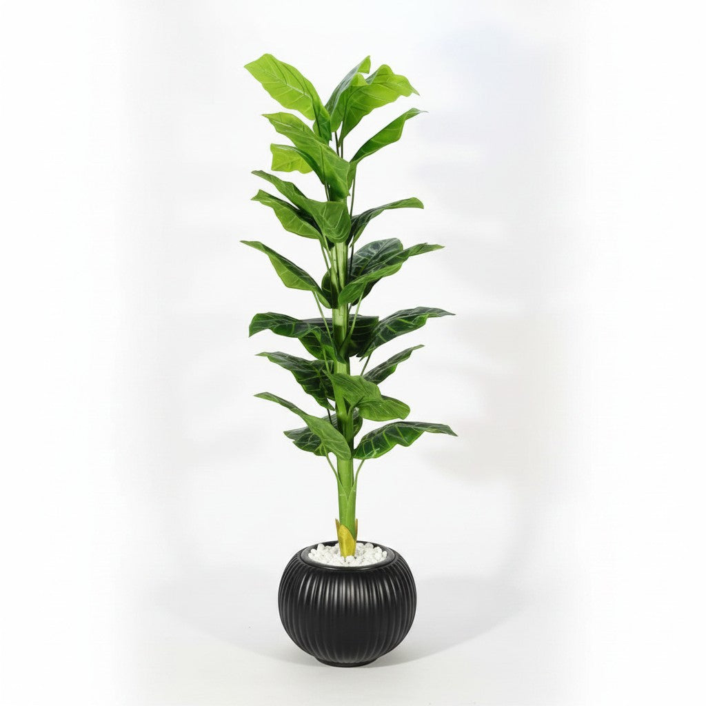 Wadi Home tall artificial indoor floor plant with vibrant green leaves in a ribbed black pot with white stone base