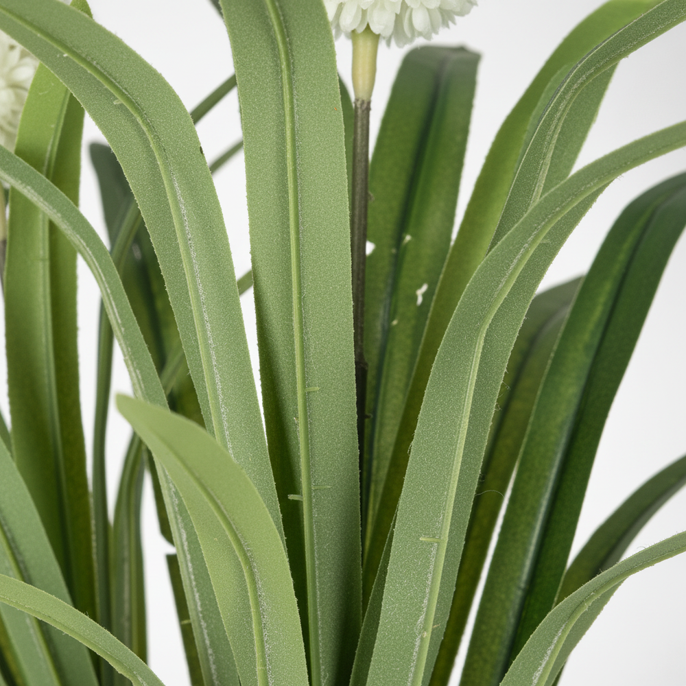 Wadi Home artificial plant featuring long green leaves and white spherical blooms in a close-up view.