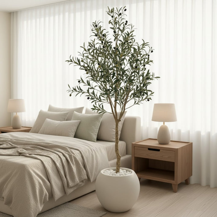 Wadi Home artificial olive tree with lush green foliage and small olives in a white round pot inside a modern bedroom