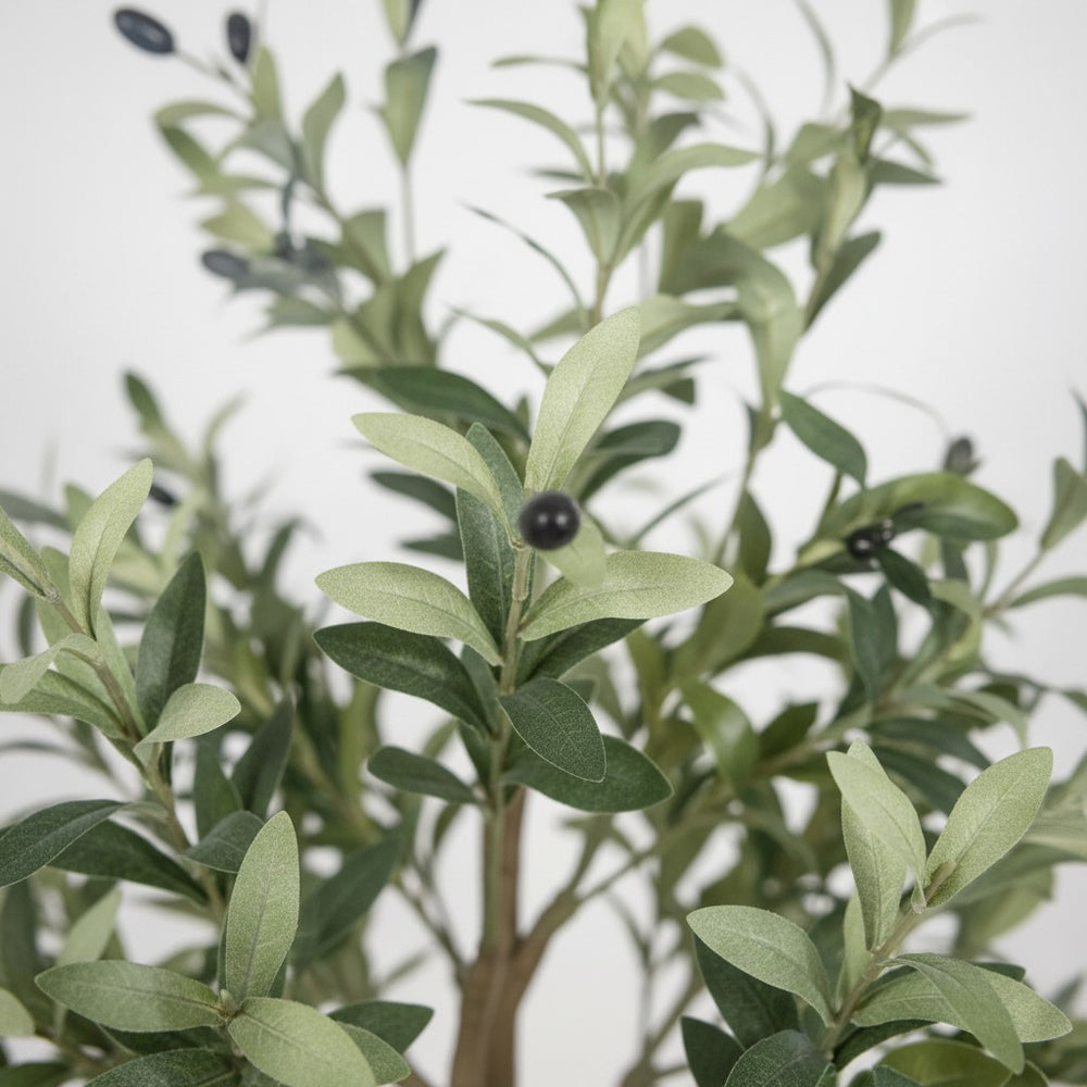 Wadi Home artificial olive tree featuring realistic silvery-green narrow leaves and dark olives on a textured branch.