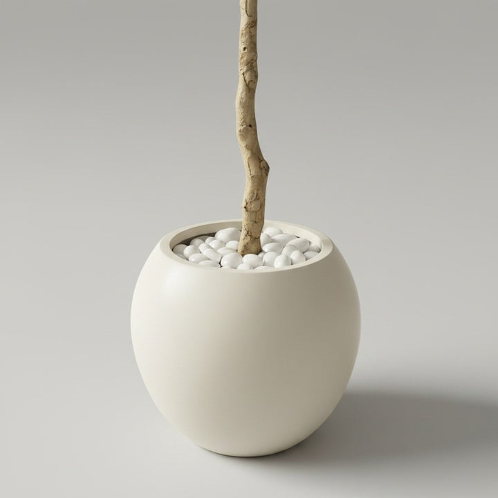 Wadi Home artificial olive tree in a minimalist round beige pot with decorative white stones on a neutral background.