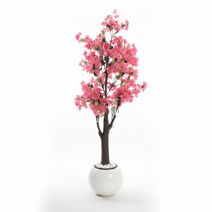 Wadi Home artificial bougainvillea tree with vibrant pink flowers in a modern white spherical planter with pebbles.