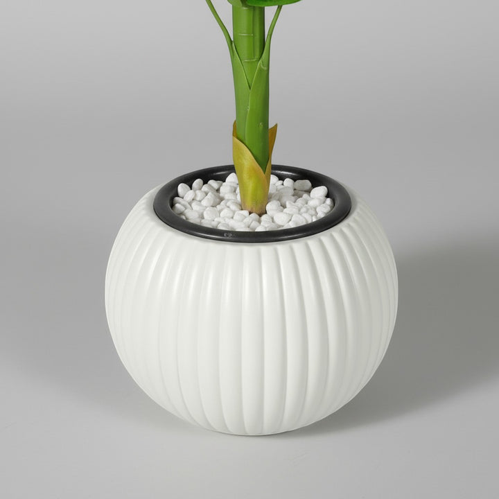 Wadi Home artificial floor plant in a round white ribbed decorative planter with a pebble-filled base