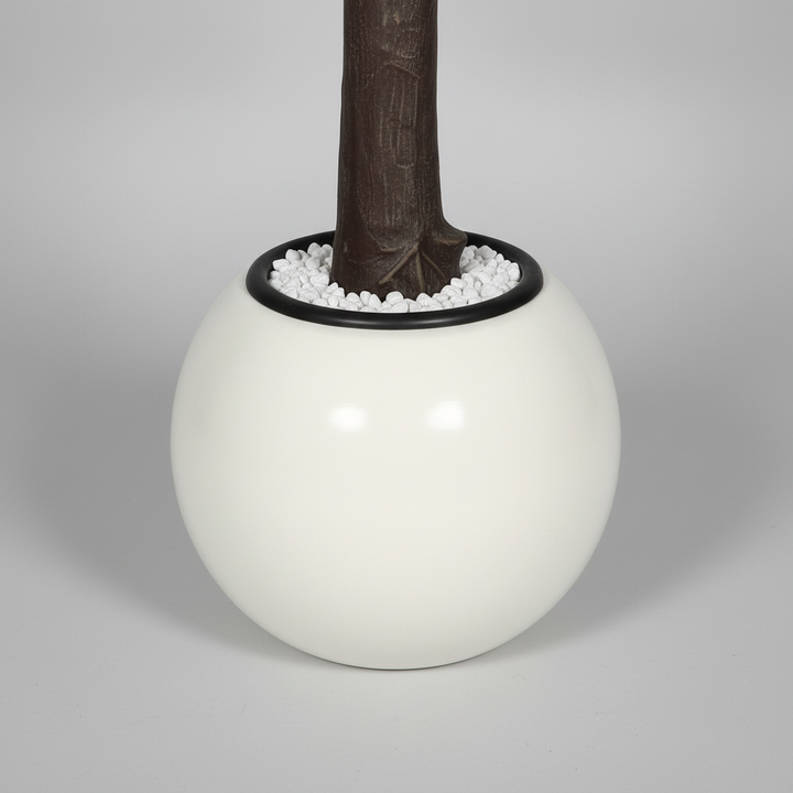 Wadi Home artificial flowering tree base featuring a textured brown trunk in a modern white spherical planter.