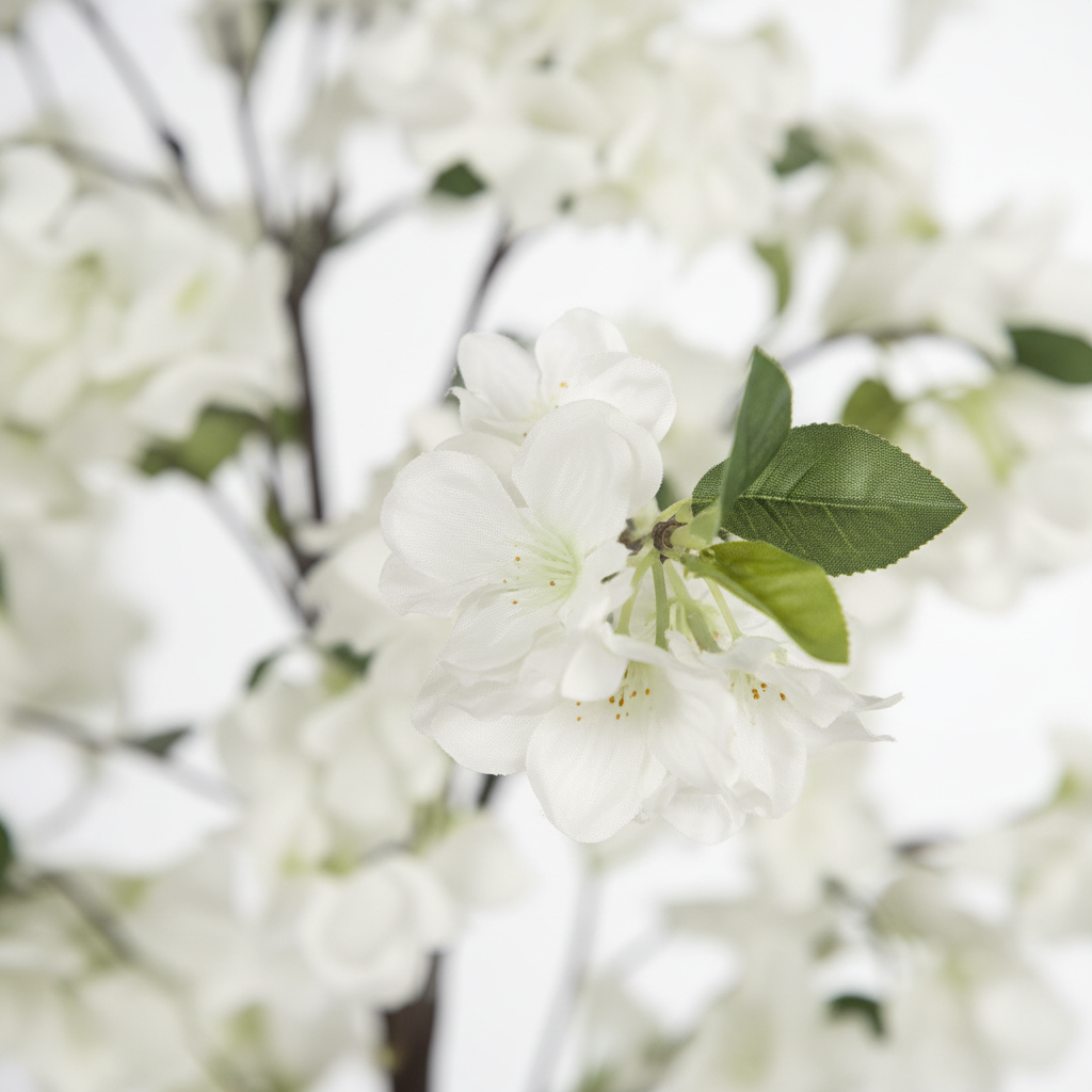 Wadi Home artificial flowering tree featuring delicate white blossoms and realistic green leaves in a close-up view