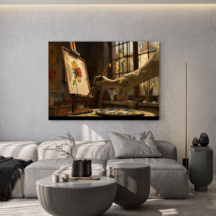 Wadi Home artist studio painting wall art featuring a floral sketch on an easel in a sunlit room above a grey sofa.