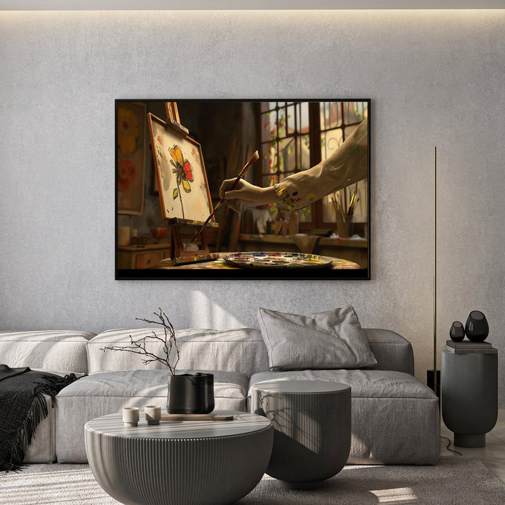 Wadi Home artist studio painting featuring a floral sketch on an easel, displayed above a modern grey sofa.