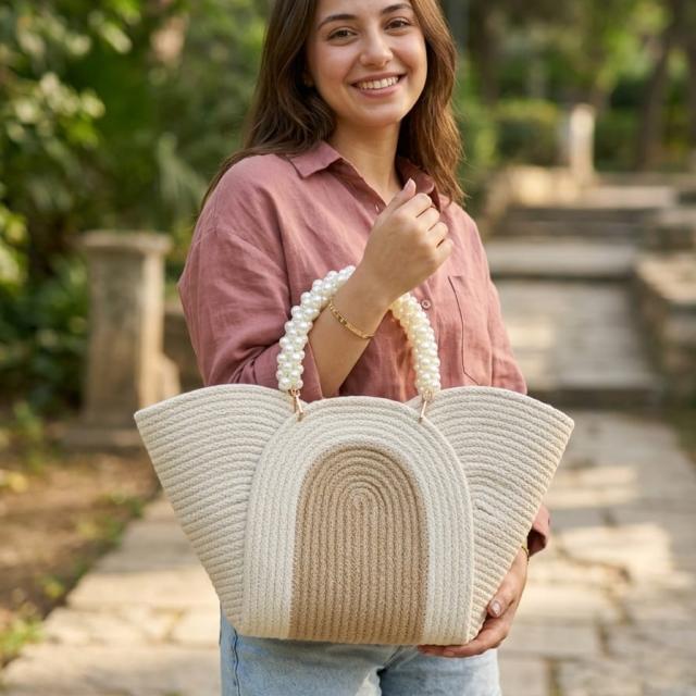 Wadi Home beige braided rope handbag with a pearl-beaded handle held by a smiling woman in a park