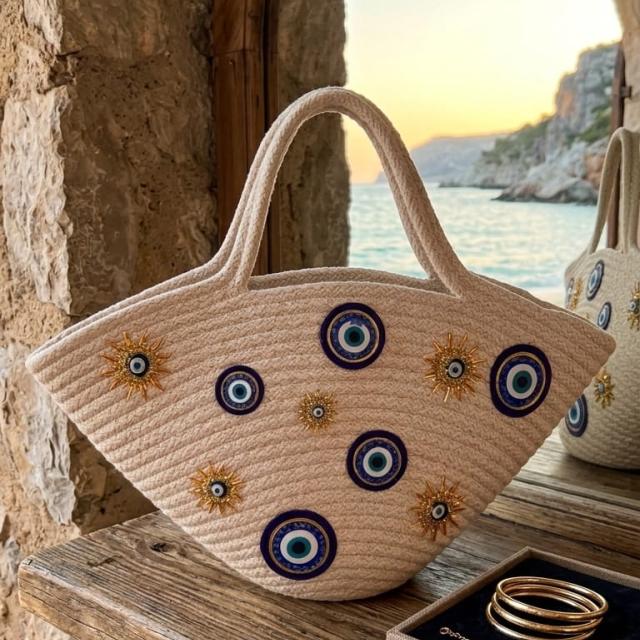 Wadi Home beige rope tote handbag with evil-eye motifs and sun-inspired embellishments in a semi-circular design.