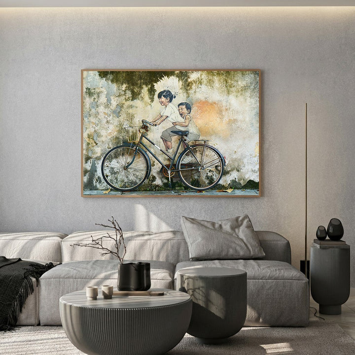 Wadi Home wall art print featuring two children riding a vintage bicycle against a weathered, textured wall.