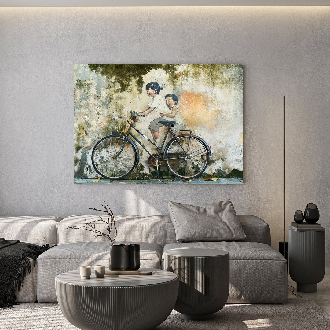 Wadi Home wall art print of two children riding a vintage bicycle against a weathered, textured urban wall.